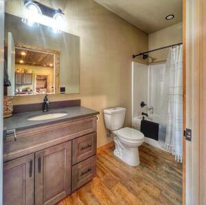 bathroom featuring shower / bath combo with shower curtain, toilet, vanity, and wood finished floors