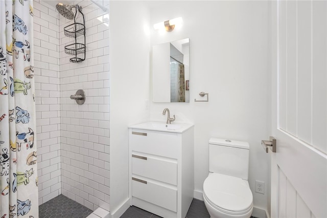 bathroom with toilet, tiled shower, and vanity