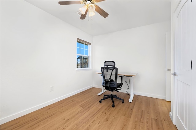 office space with light wood-style flooring, a ceiling fan, and baseboards