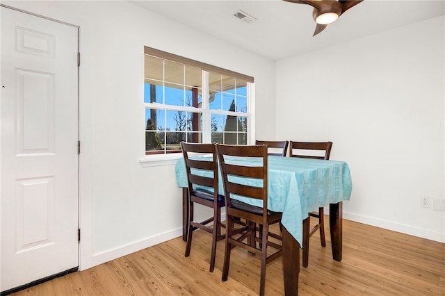 dining area featuring visible vents, baseboards, a ceiling fan, and wood finished floors