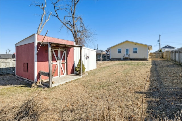 exterior space with a storage unit, an outdoor structure, and a fenced backyard