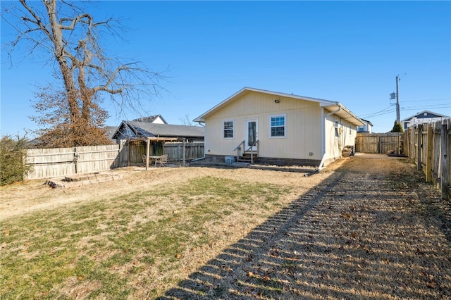 back of house with a yard, a fenced backyard, and entry steps