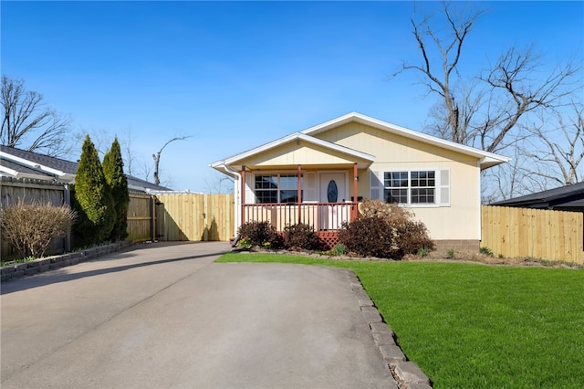 bungalow-style home with a gate, covered porch, a front lawn, and fence