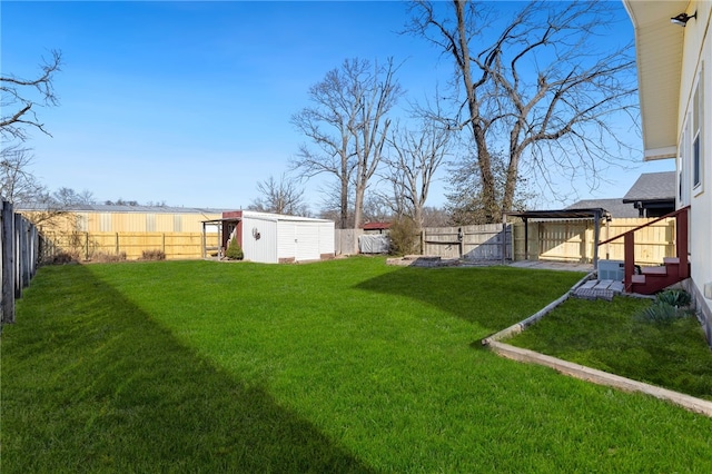 view of yard featuring a fenced backyard, a storage shed, and an outdoor structure