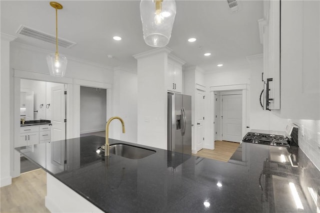 kitchen featuring visible vents, ornamental molding, appliances with stainless steel finishes, and a sink