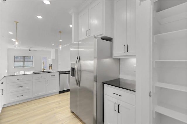 kitchen with white cabinets, light wood-style flooring, appliances with stainless steel finishes, and a sink