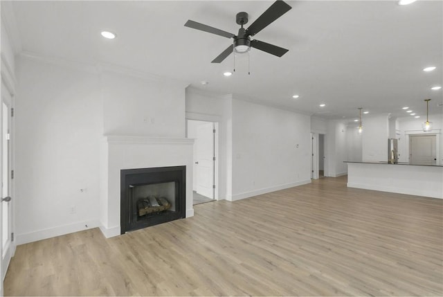 unfurnished living room with crown molding, baseboards, ceiling fan, recessed lighting, and light wood-style flooring