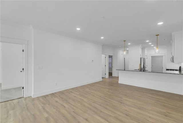 unfurnished living room with recessed lighting, light wood-type flooring, baseboards, and crown molding