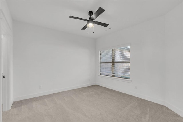 unfurnished room with a ceiling fan, baseboards, and light carpet