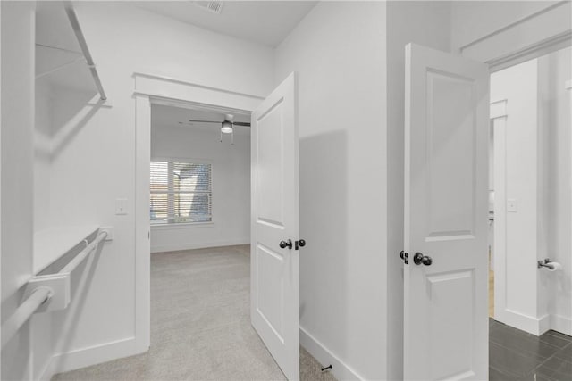 corridor featuring visible vents, baseboards, and carpet