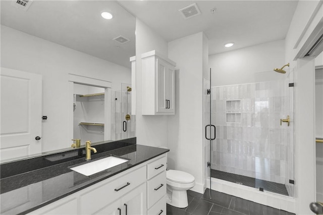 bathroom with visible vents, a stall shower, toilet, and vanity