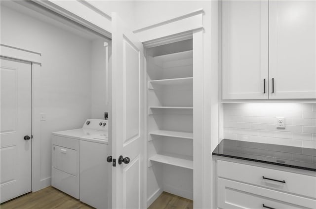 clothes washing area with cabinet space, wood finished floors, and hookup for an electric dryer