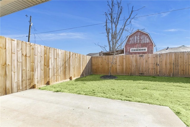 view of yard featuring a patio, a barn, a fenced backyard, and an outdoor structure