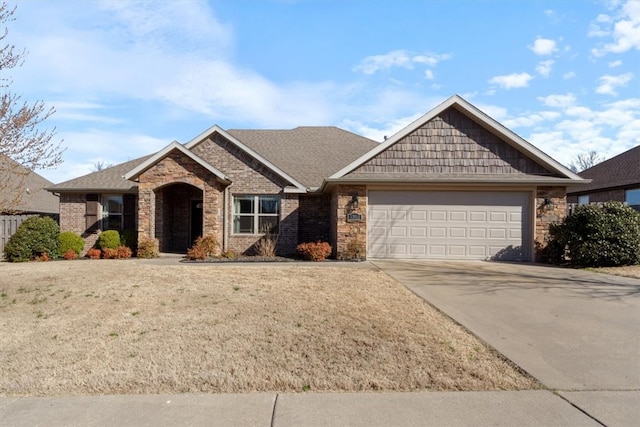 view of front of home featuring driveway, stone siding, a front yard, a garage, and brick siding