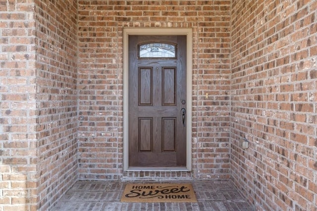 property entrance featuring brick siding