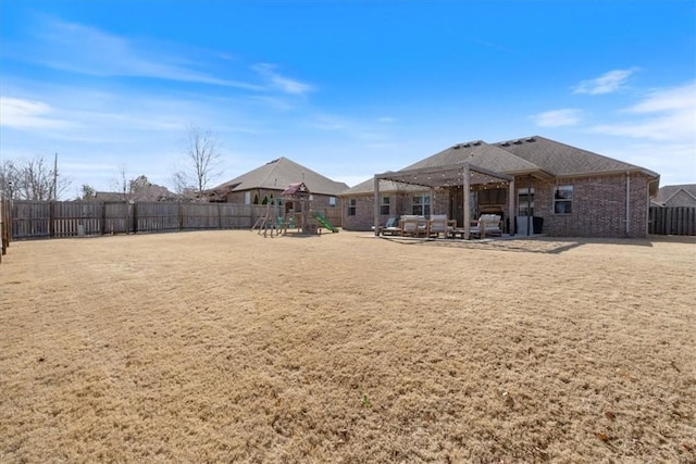 back of property with a patio, a fenced backyard, a playground, a yard, and brick siding