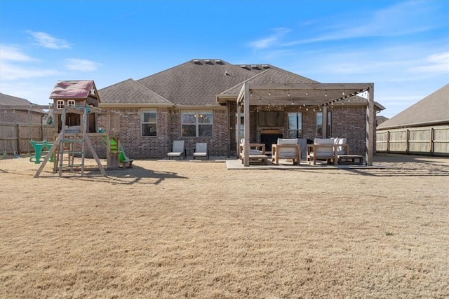 rear view of property featuring brick siding, a patio, a playground, and a fenced backyard