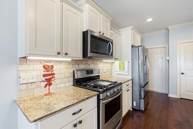 kitchen featuring light stone counters, dark wood finished floors, stainless steel appliances, white cabinets, and crown molding