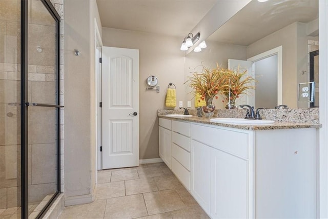 full bathroom featuring a shower stall, double vanity, tile patterned floors, and a sink