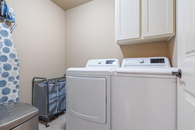 clothes washing area with cabinet space and separate washer and dryer