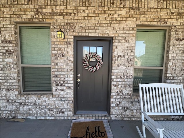 property entrance featuring brick siding