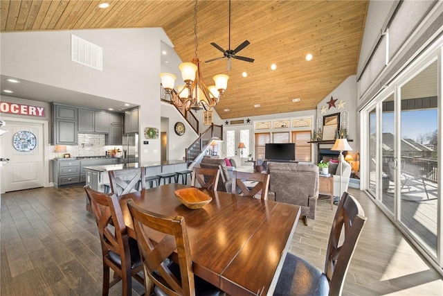 dining space with visible vents, stairs, wooden ceiling, dark wood-style floors, and high vaulted ceiling