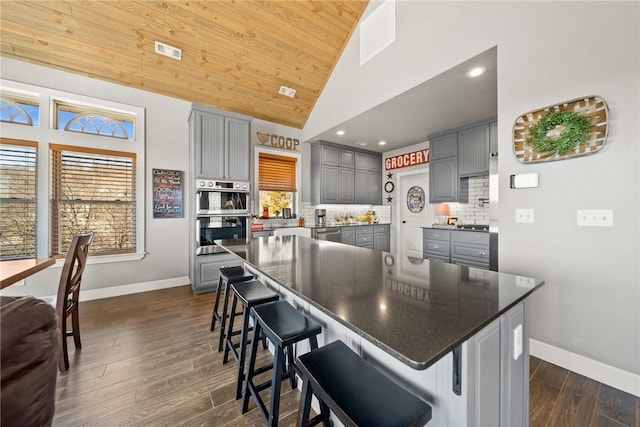 kitchen featuring stainless steel appliances, backsplash, and gray cabinets