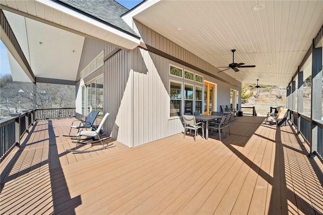 wooden deck featuring outdoor dining space and a ceiling fan