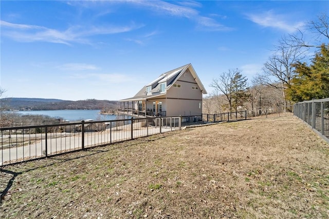 view of yard featuring a fenced backyard and a water view