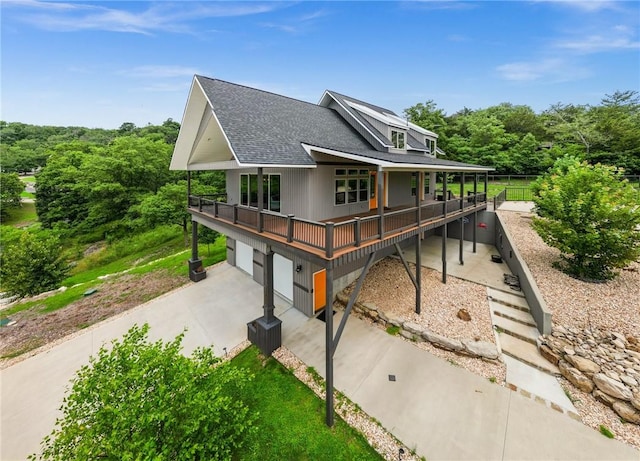 14137 Ozark Dr, Garfield, AR 72732 - view of front facade with a shingled roof, a garage, concrete driveway, and covered porch