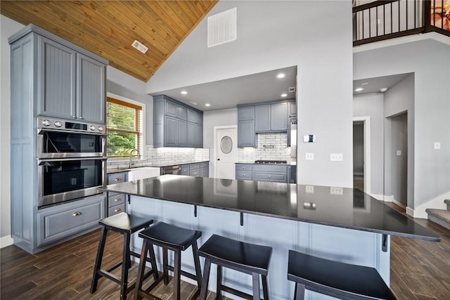 14137 Ozark Dr, Garfield, AR 72732 - kitchen featuring gray cabinetry, dark wood finished floors, stainless steel appliances, wooden ceiling, and high vaulted ceiling