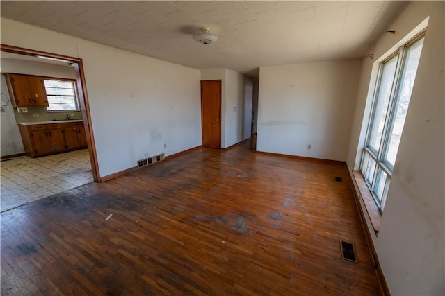 empty room featuring visible vents, baseboards, and hardwood / wood-style floors