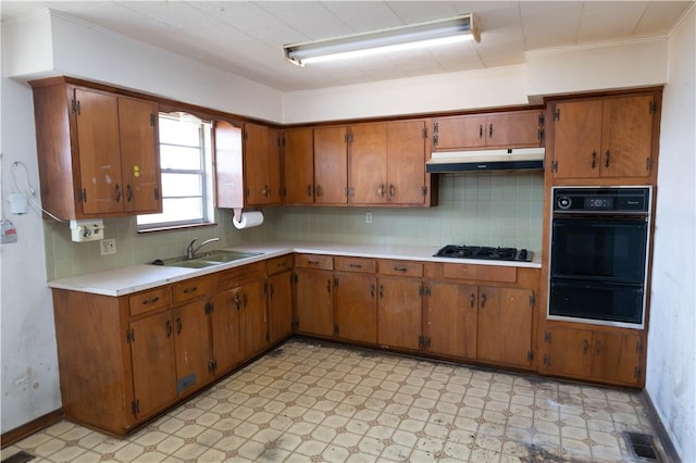 kitchen featuring black appliances, under cabinet range hood, a sink, light countertops, and light floors