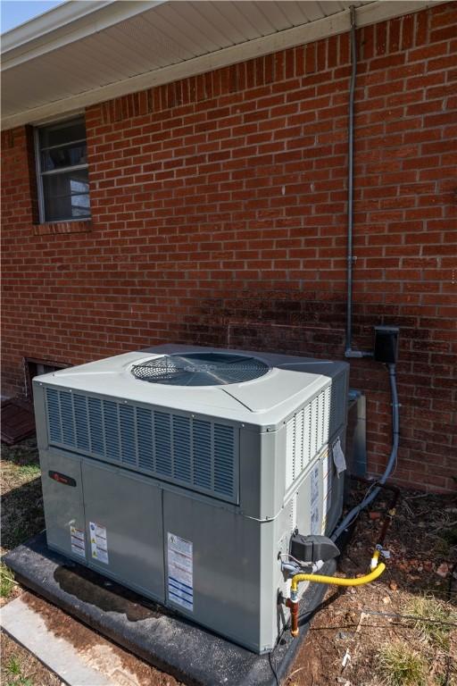 details featuring central air condition unit and brick siding