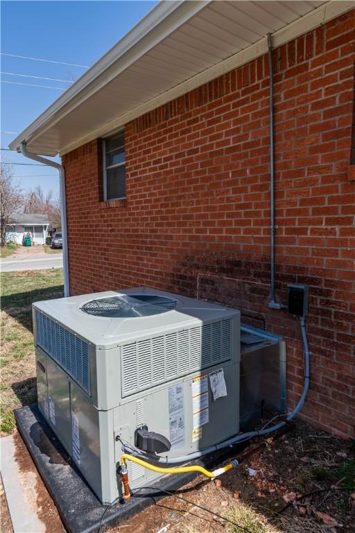 details featuring cooling unit and brick siding