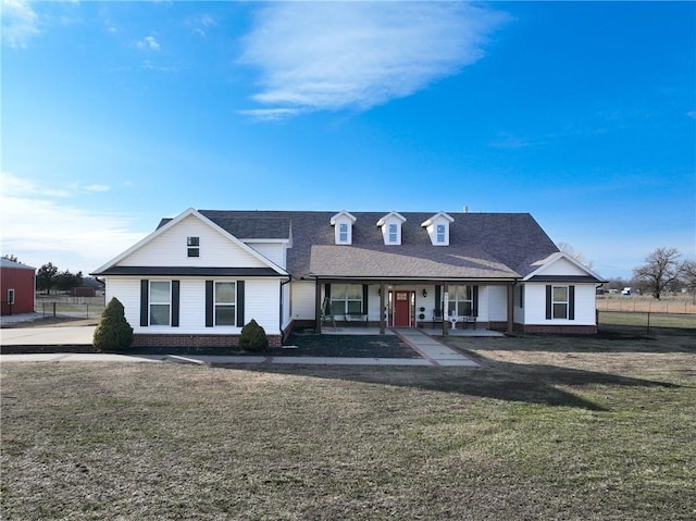 view of front of home featuring a porch, a shingled roof, a front lawn, and fence