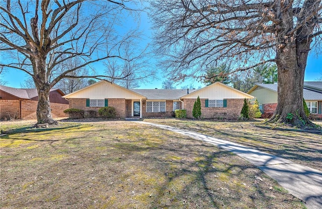 ranch-style home featuring brick siding and a front lawn