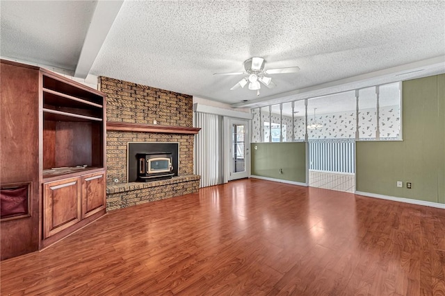 unfurnished living room featuring wood finished floors, a ceiling fan, baseboards, and a textured ceiling