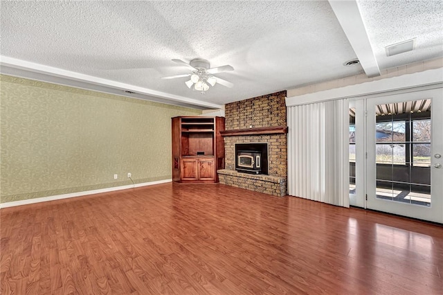 unfurnished living room with wood finished floors, a ceiling fan, and a textured ceiling