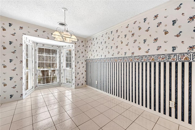 spare room with tile patterned flooring, wallpapered walls, crown molding, a notable chandelier, and a textured ceiling