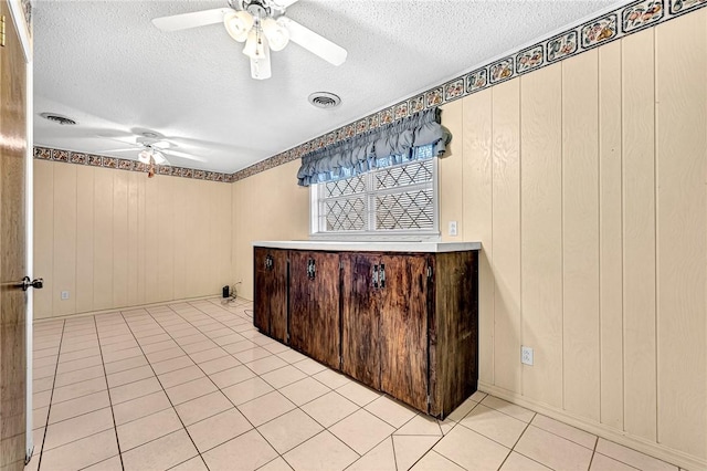 unfurnished room with visible vents, a textured ceiling, and a ceiling fan