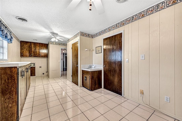 kitchen featuring visible vents, a textured ceiling, a ceiling fan, and light countertops