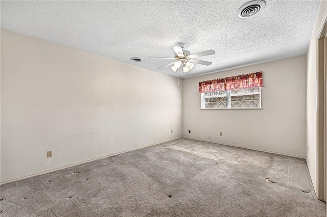 carpeted empty room featuring a textured ceiling, visible vents, and ceiling fan