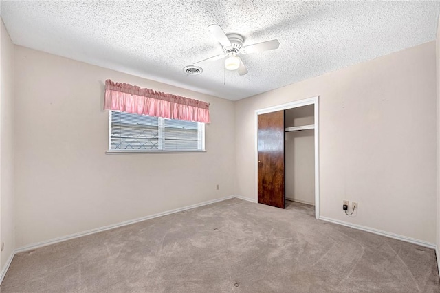 unfurnished bedroom featuring visible vents, baseboards, carpet, a closet, and a textured ceiling