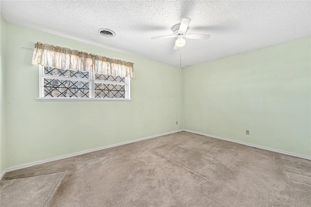 carpeted empty room with visible vents, baseboards, a textured ceiling, and a ceiling fan