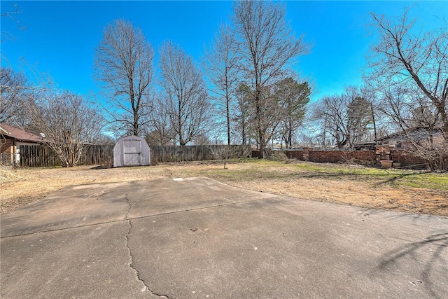 view of yard featuring an outbuilding, a storage unit, and fence private yard