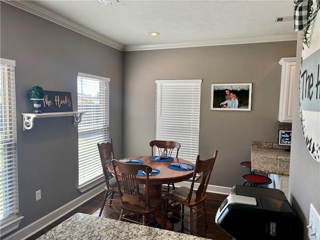 dining room featuring visible vents, baseboards, dark wood-type flooring, and ornamental molding