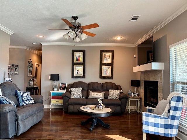 living area featuring visible vents, a textured ceiling, wood finished floors, and a ceiling fan