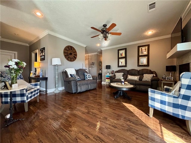 living room featuring visible vents, a textured ceiling, wood finished floors, and a ceiling fan