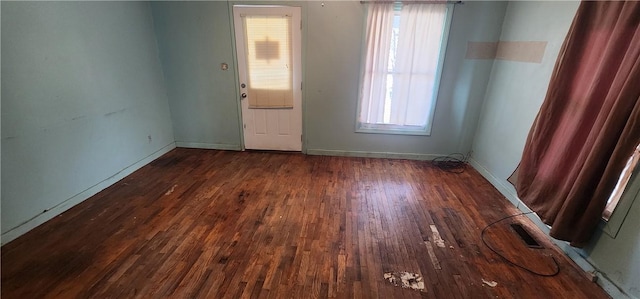 empty room featuring visible vents, baseboards, and wood finished floors